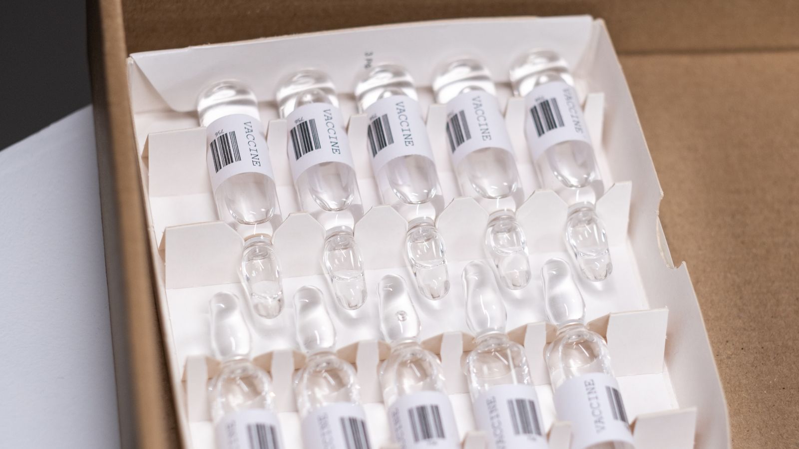 Close-up of a box containing multiple transparent medication vials arranged in an organized layout.